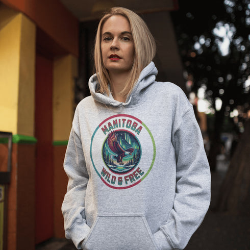 Soar high in our Manitoba – Wild & Free hoodie, featuring a bold flying bald eagle beneath the captivating northern lights.